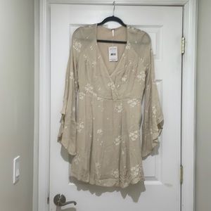 Cute and chic tan with stitches floral design and flowy sleeves.